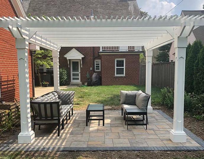 backyard white vinyl pergola over paver patio