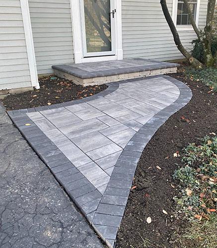 Paver walkway and patio steps leading up to front door
